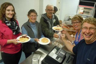 L-r Elizabeth Conbery, Joan and Rudy Hollywood are served up a pancake breakfast courtesy of Anne Howes and Randy McVety at GREC's annual United Way breakfast fundraiser on Oct. 21. Not in the photo but also helping out in the kitchen was Amy McDonald.